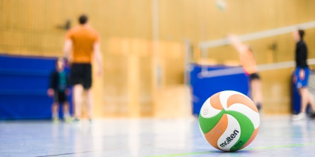 Ein Ball liegt auf dem Boden in einer Sporthalle.